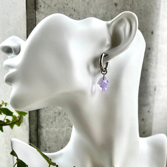 Lilat Swarovski Cosmic drop riipukset hopeanvärisillä huggierenkailla.