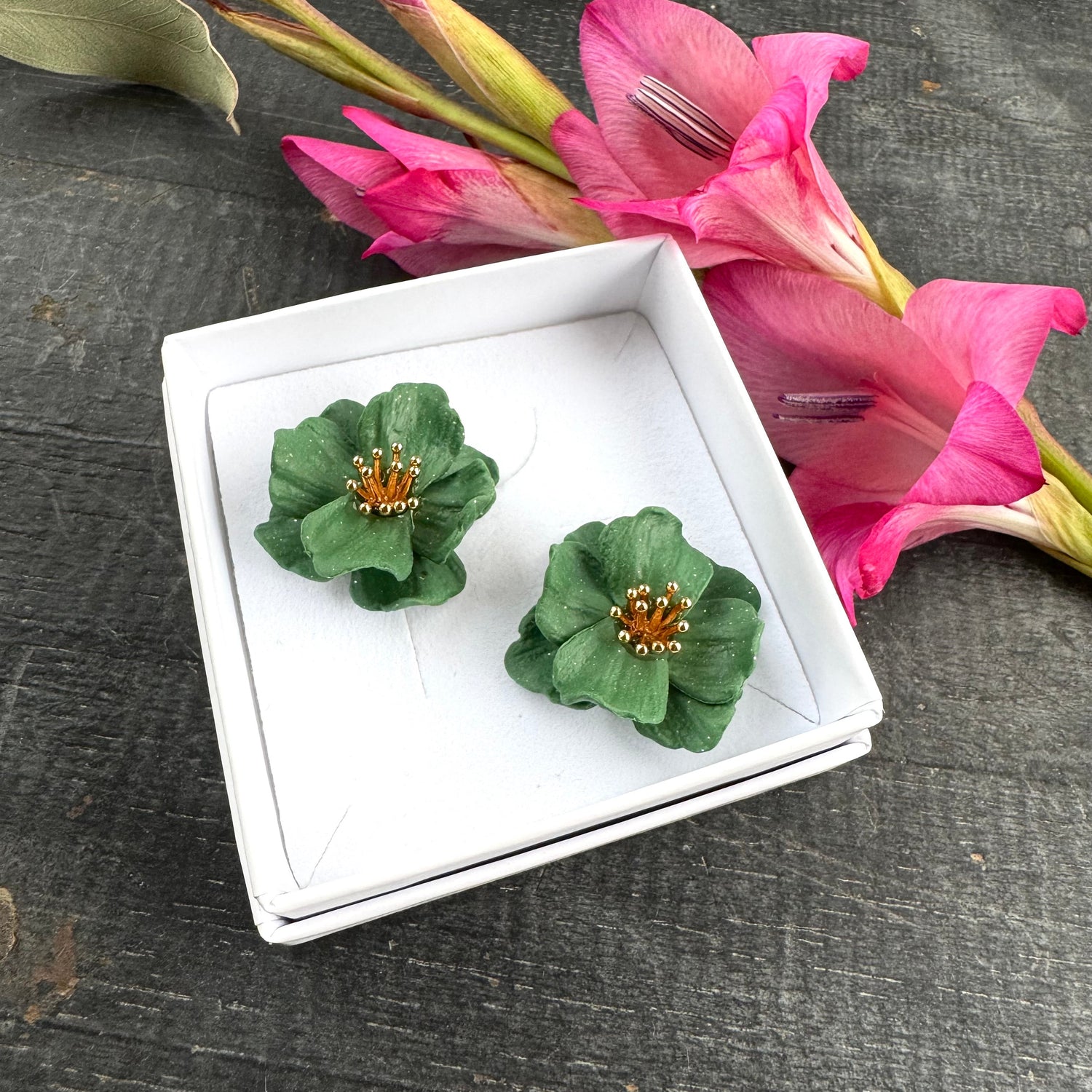 Vihreät polymeerimassasta käsin muotoillut vihreät kukkanappikorvikset. Keskellä metallinen hedeosa, jonka voi valita joko kullan- tai hopeanvärisenä.