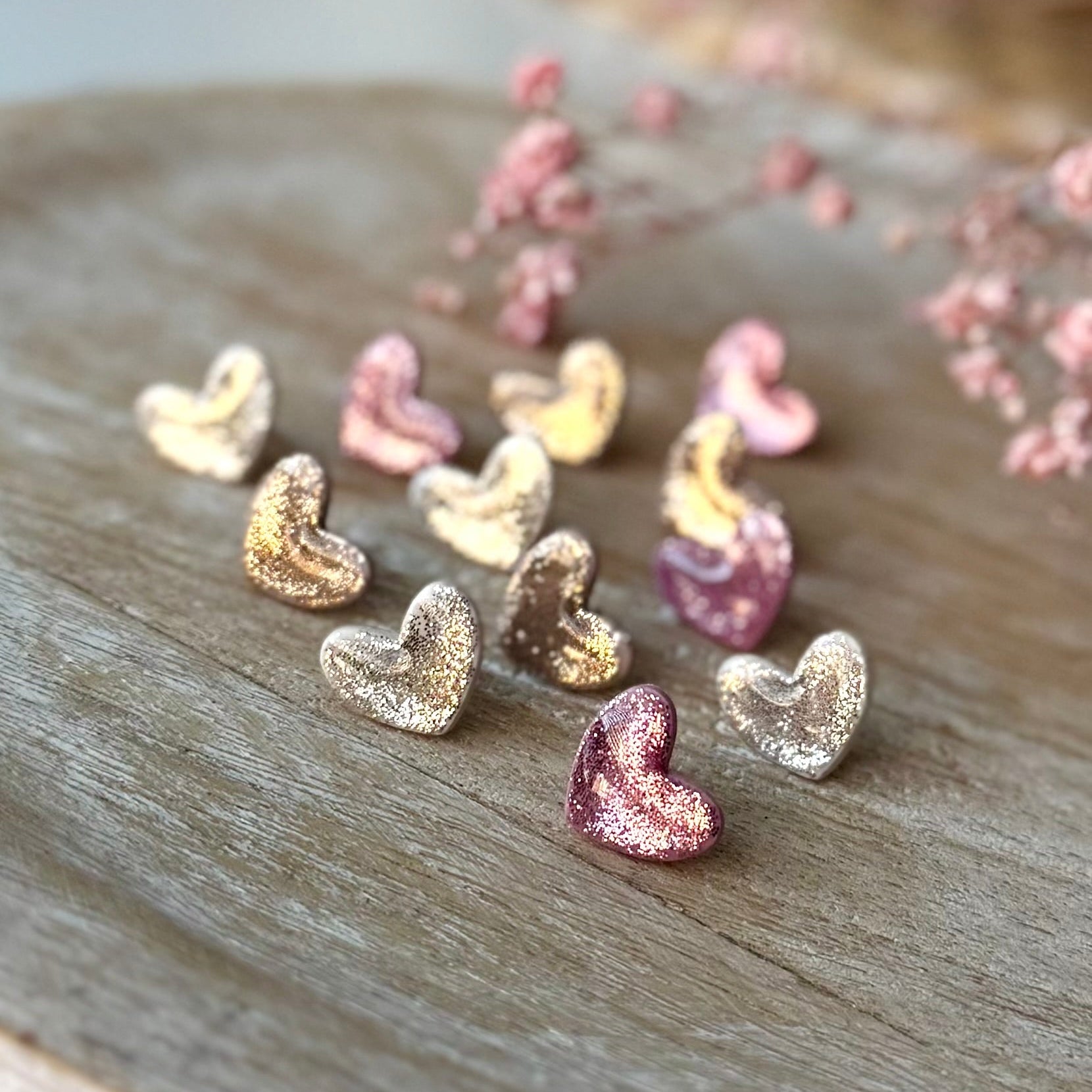 Pienet sydän nappikorvakorut glitterin kimalluksella.