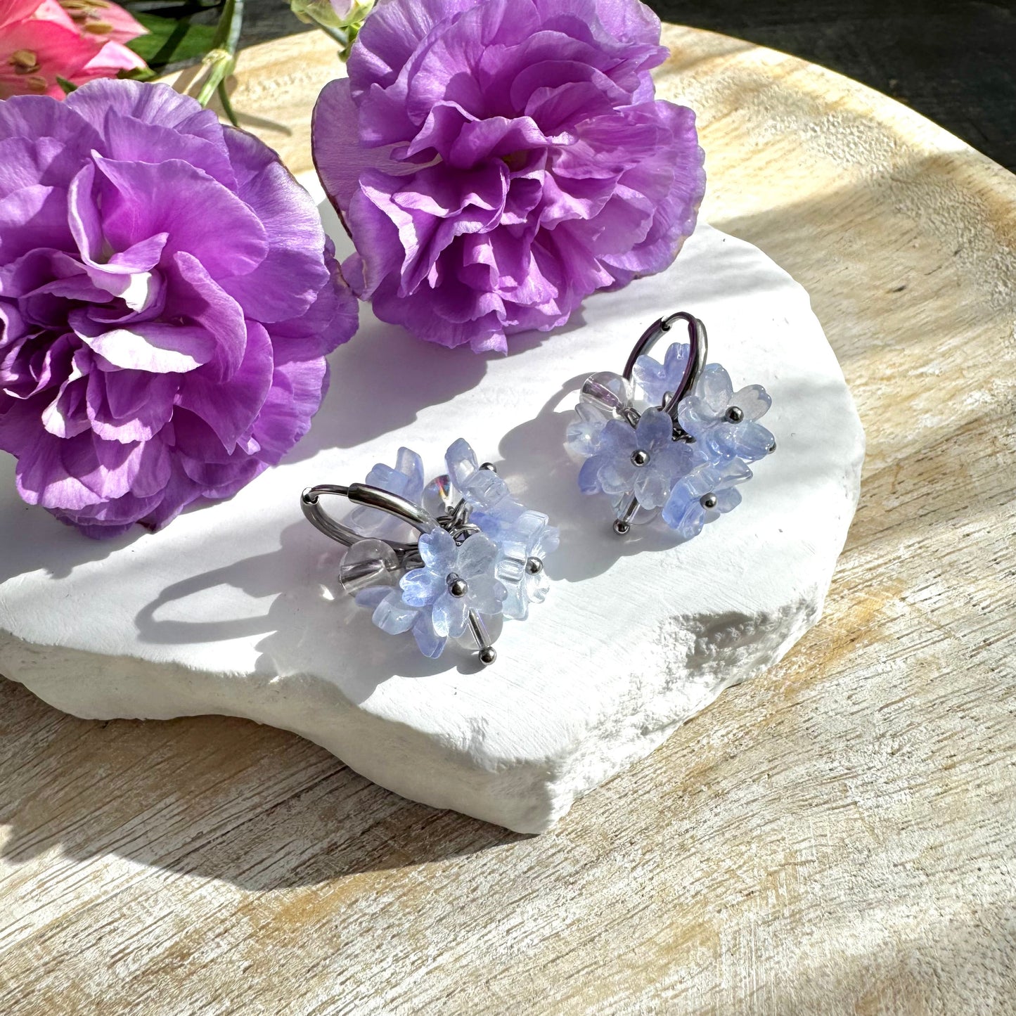 Vaaleansiniset kukkakorvakorut huggie-renkaalla.