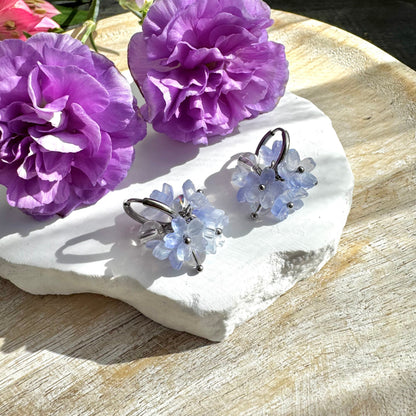 Vaaleansiniset kukkakorvakorut huggie-renkaalla.